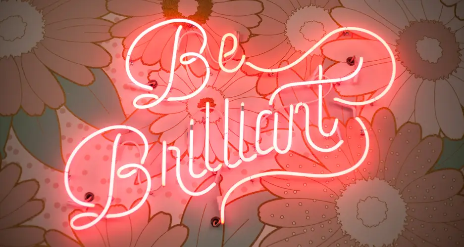 Ein Bild mit einem Schriftzug aus Neonröhren mit den Worten 'Be Brilliant'